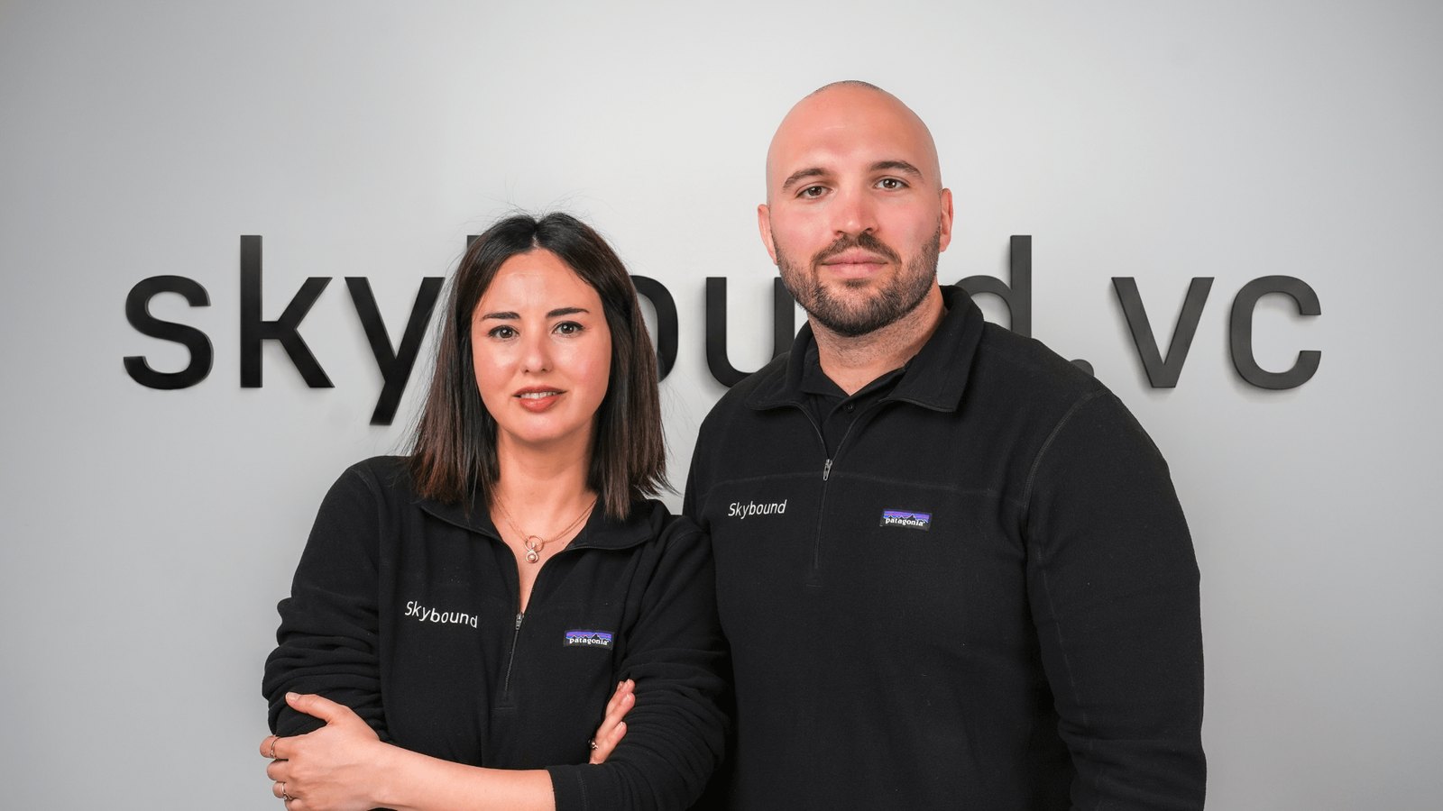 Thaleia Misailidou and George Varvarelis, co-founders and General Partners of Skybound Venture Capital, in front of the skybound.vc wall